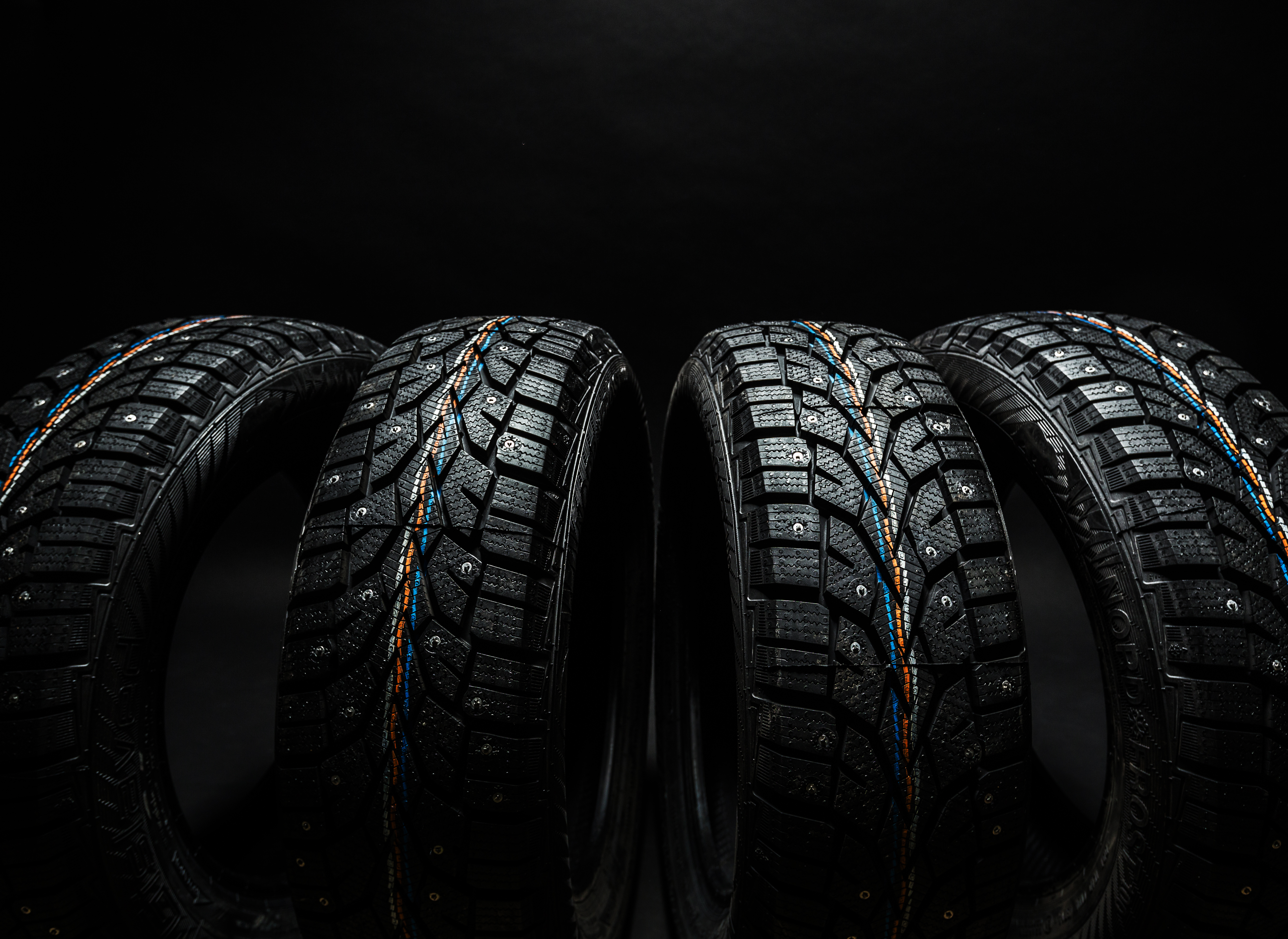 Set of winter tires on a dark studio backdrop
